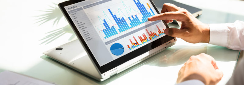 Close-up,Of,A,Businessman's,Hand,Analyzing,Graph,On,Laptop,At